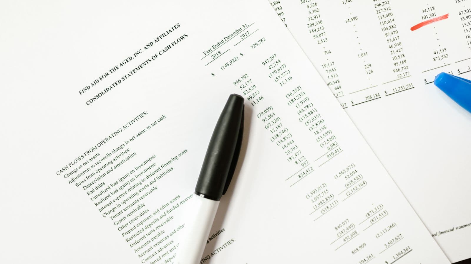 Dokumenty finansowe i notatki wykorzystywane do analizy spółki.