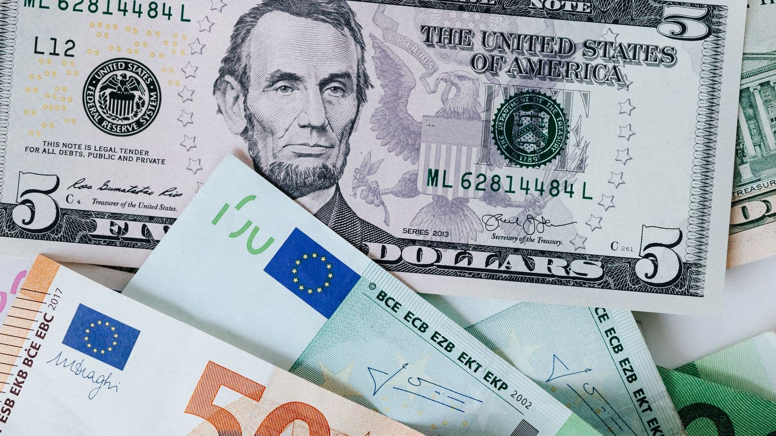 Banknoty różnych walut ułożone obok siebie.