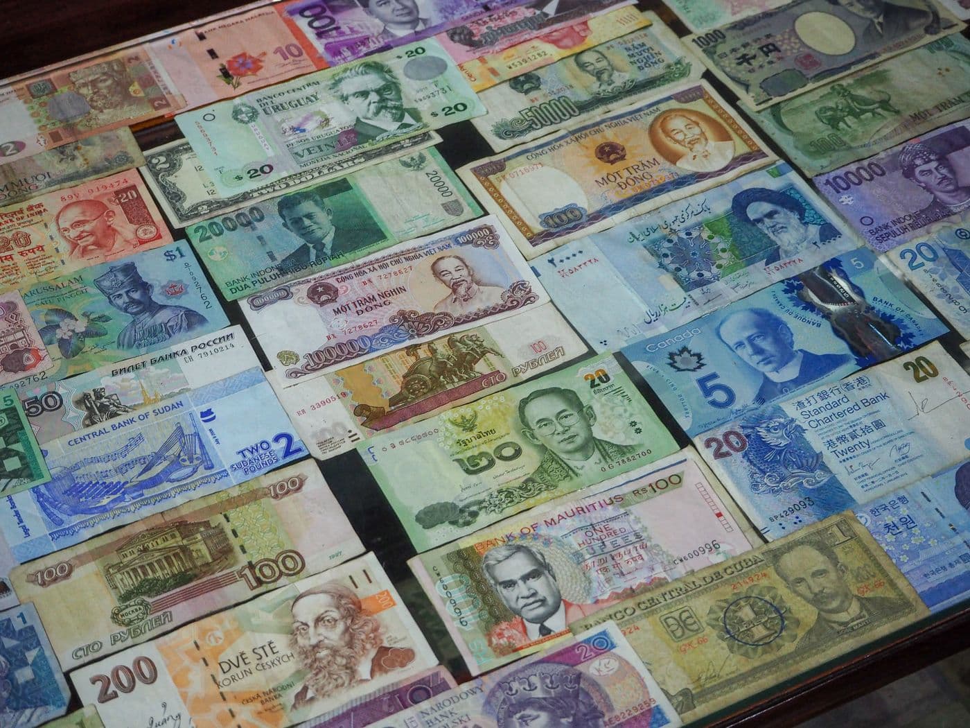 Kolorowe banknoty z różnych krajów pokazujące wiele walut rachunku.