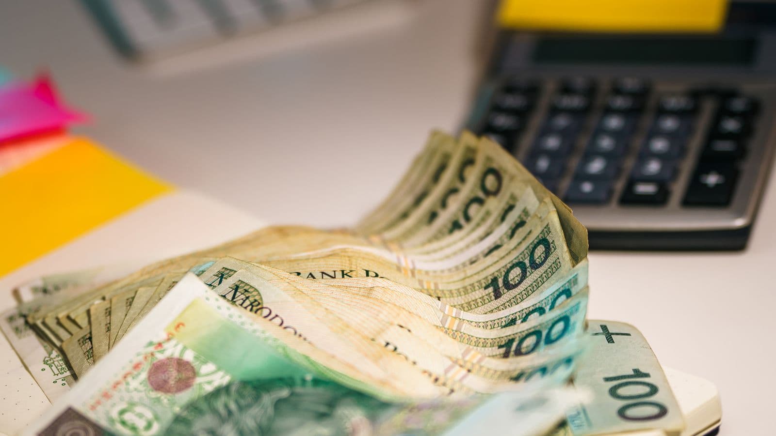 Polskie banknoty i kalkulator używane do planowania oszczędności.